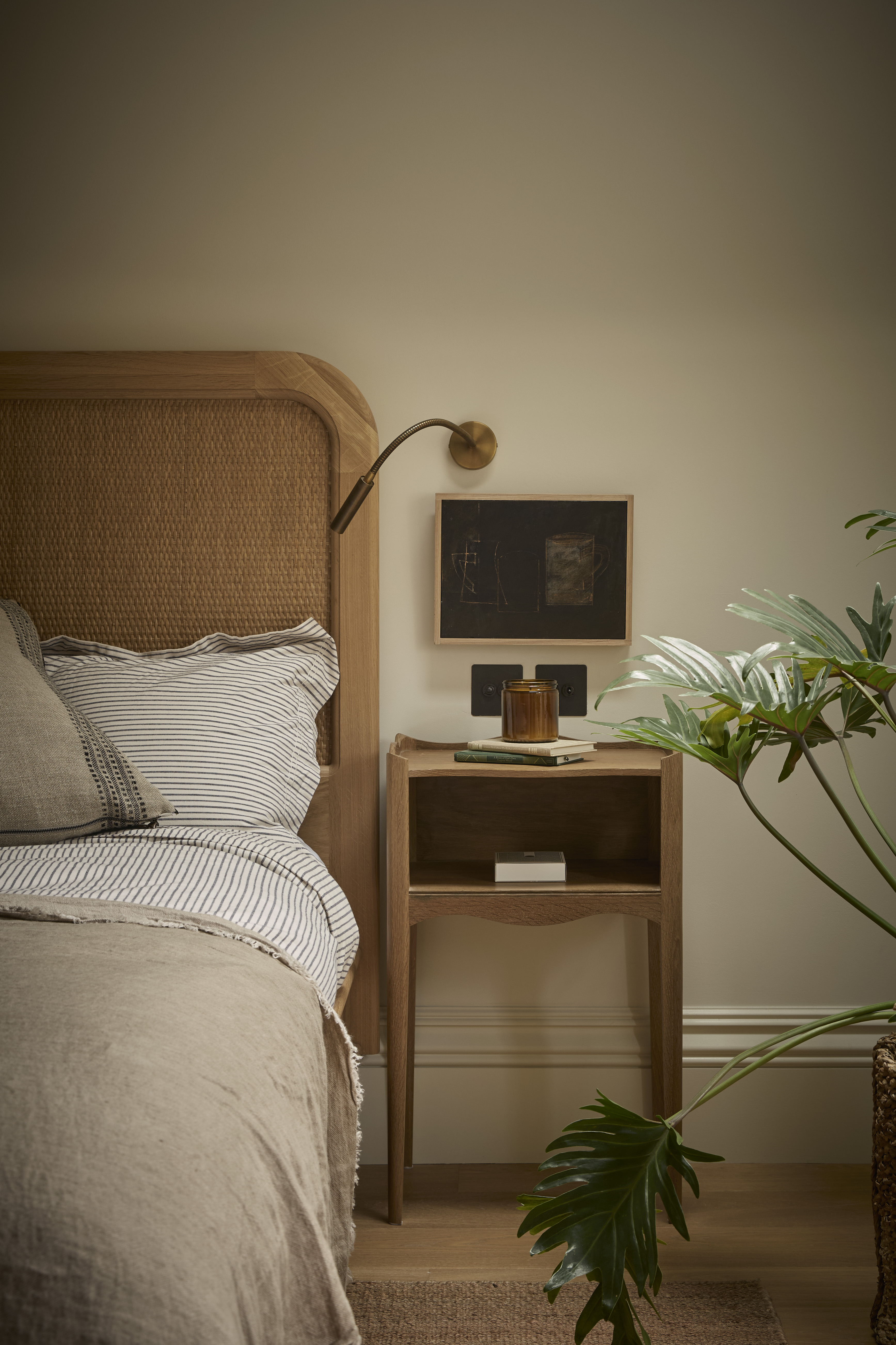 bedroom with a wooden headboard and side table, and a bronze bedside lamp