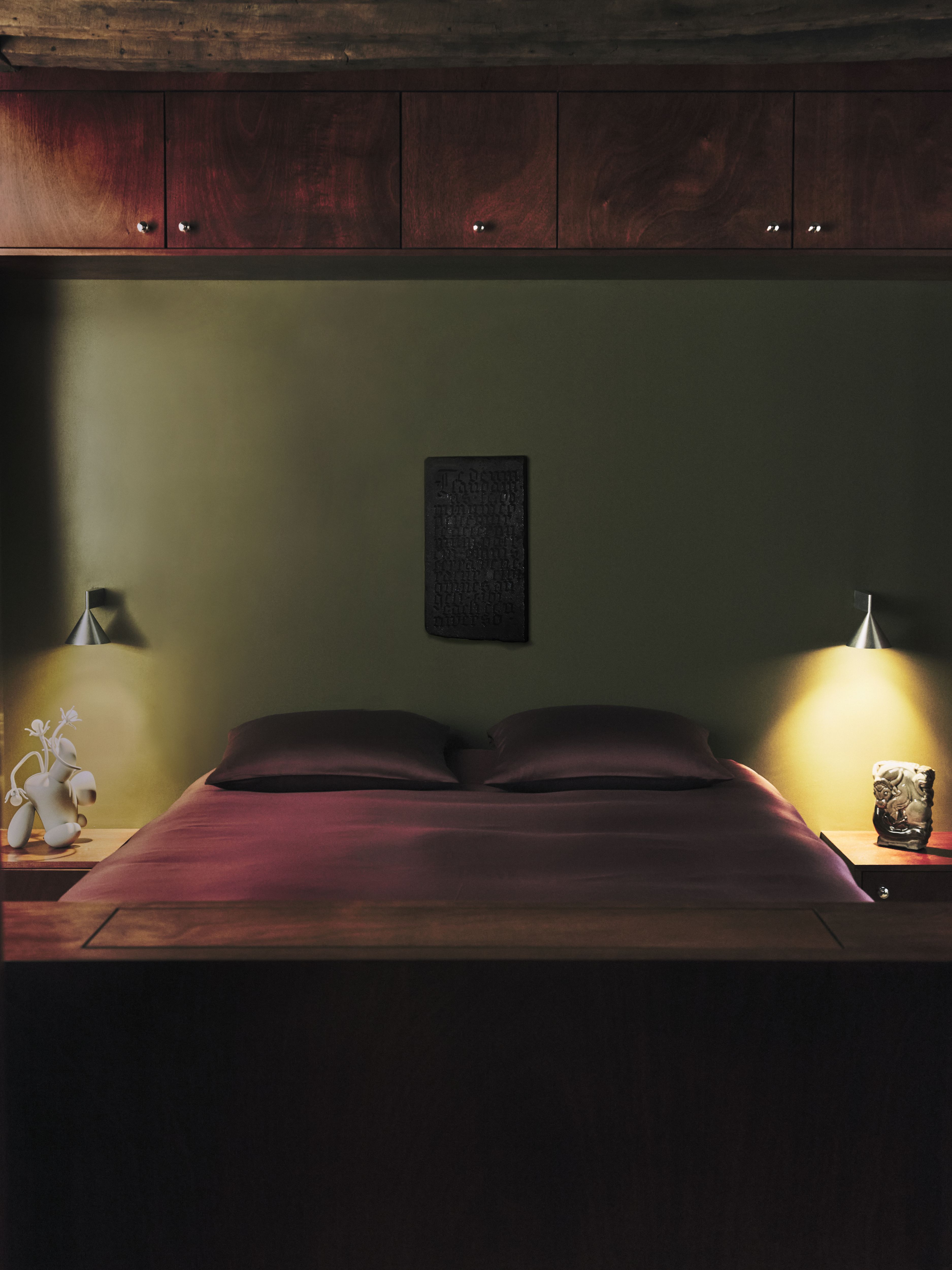 A sleekly designed apartment with tiled white and black checkered floors, chrome surfaces, brick walls, and occasional pops of red, ming green, and butter across linearly cut furniture.