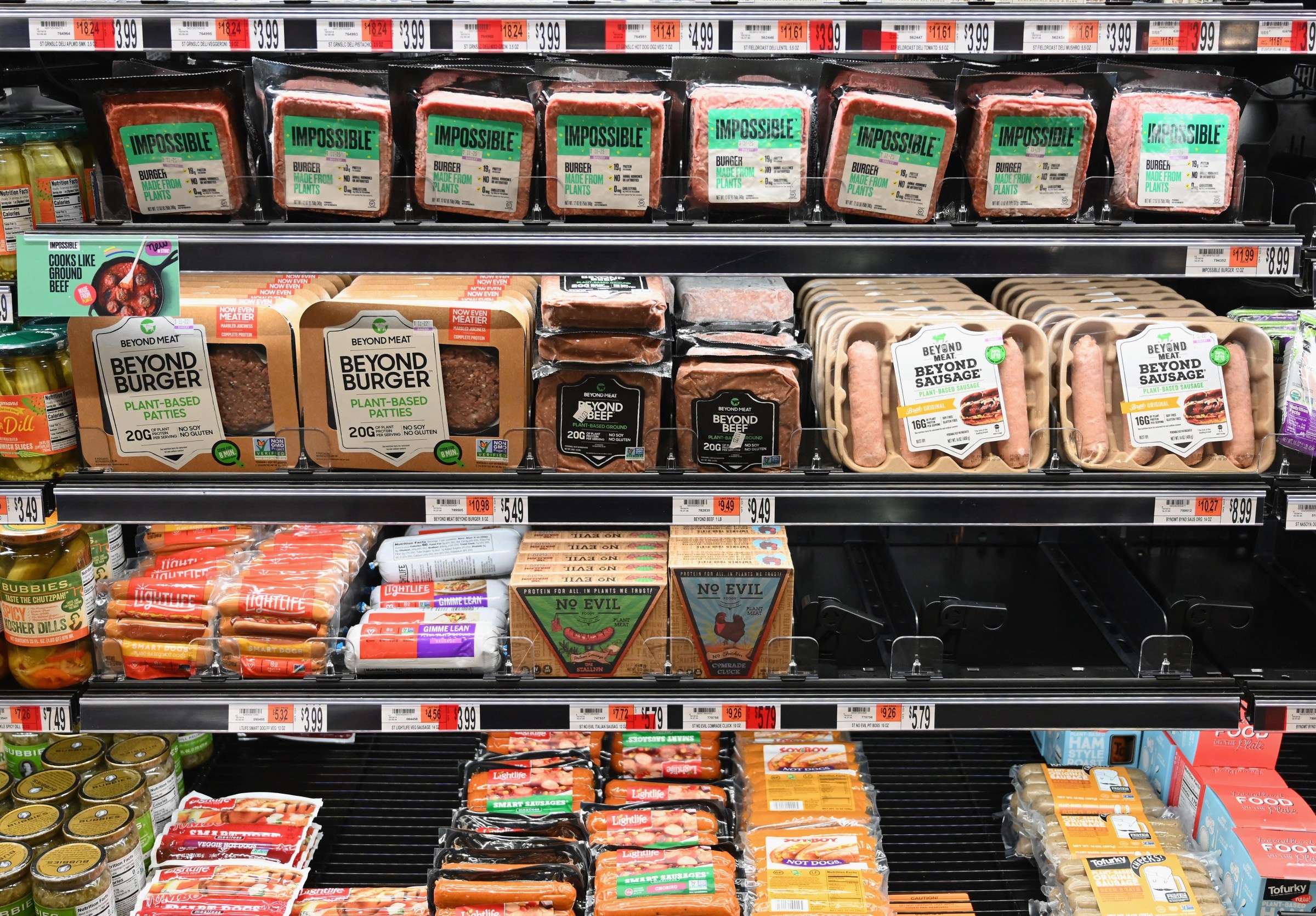 A grocery store shelf filled with plant-based meat products.