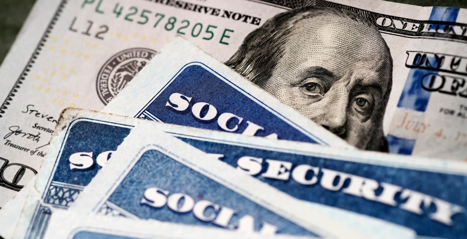 File Photo: A stack of U.S. Social Security cards on top of a $100 bill.