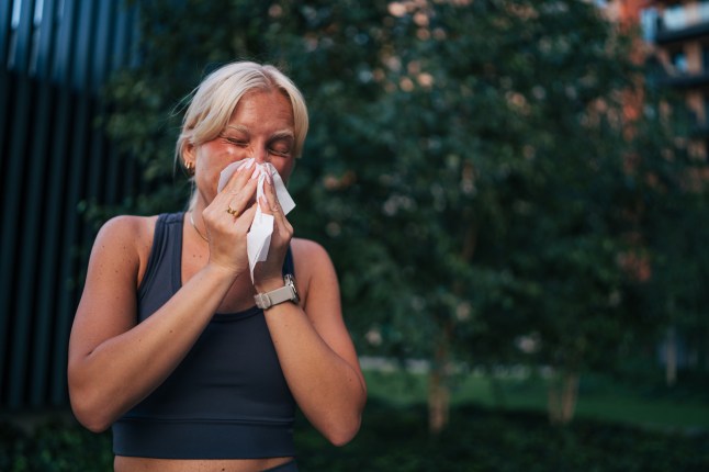 Young sporty woman blowing nose after training outdoors