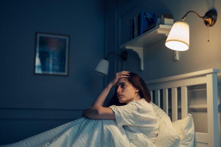 Woman in bed at night having trouble sleeping. - stock photo