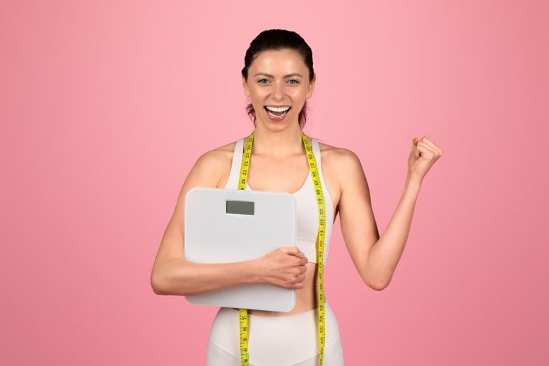 Happy Young Woman Celebrating Weight Loss Success Holding Scale