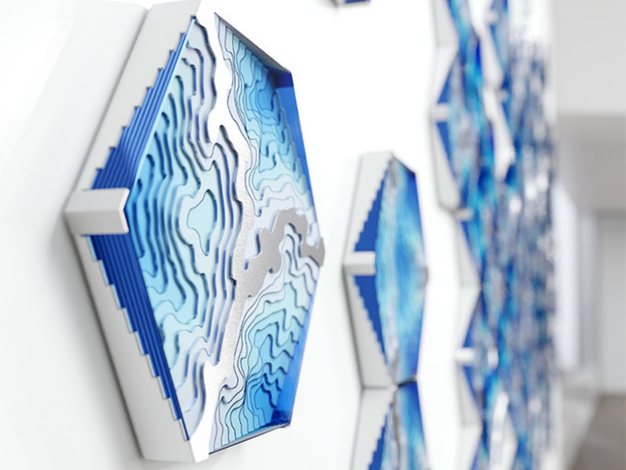 Abstract blue layered wall sculpture in a row, forming a wave-like pattern, seen from a close-up perspective in a bright modern space.