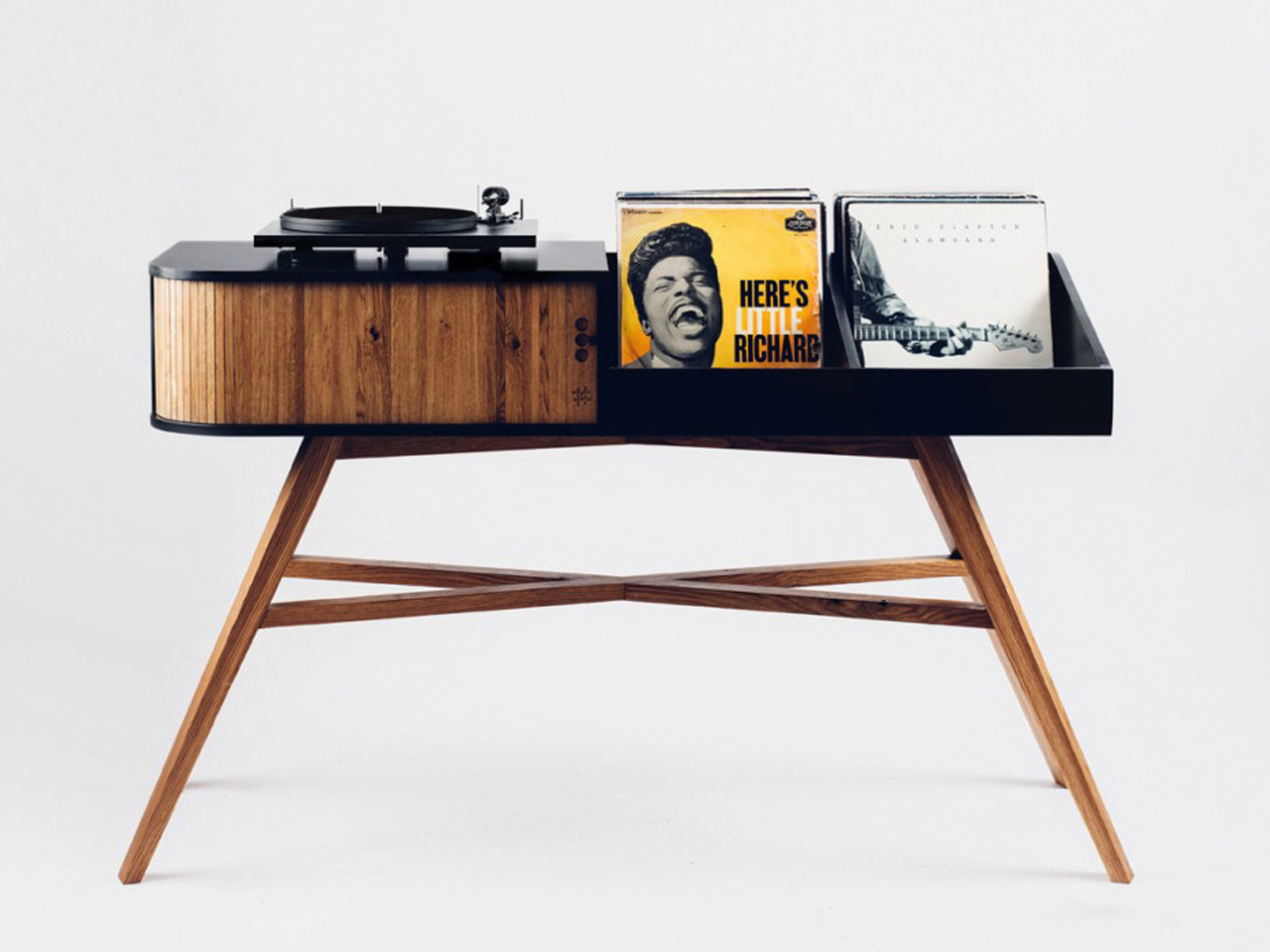 Mid-century wooden record player on a black tray with two vinyl records displayed beside it .