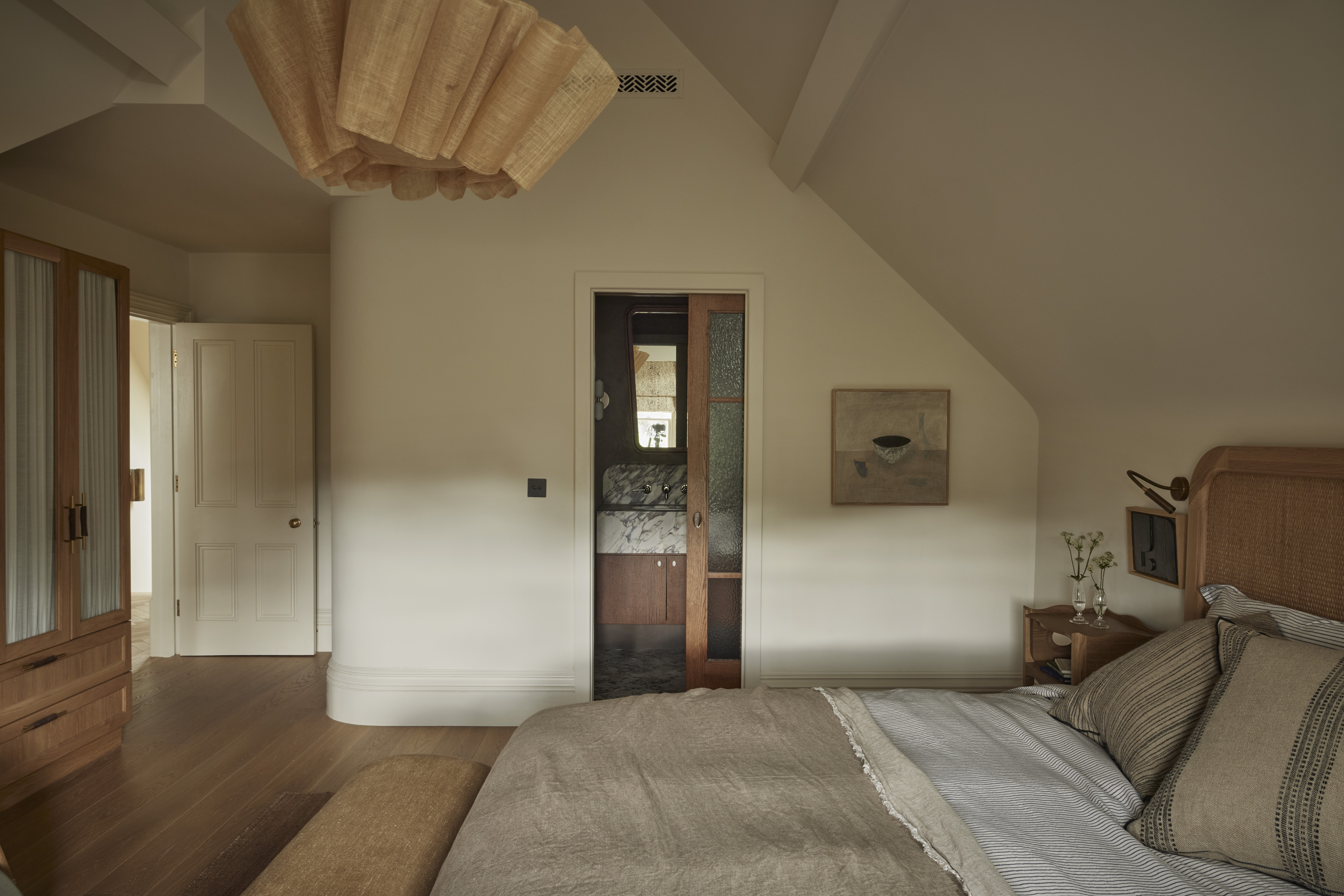 Beautiful loft conversion guest bedroom decorated in neutral tones and natural materials