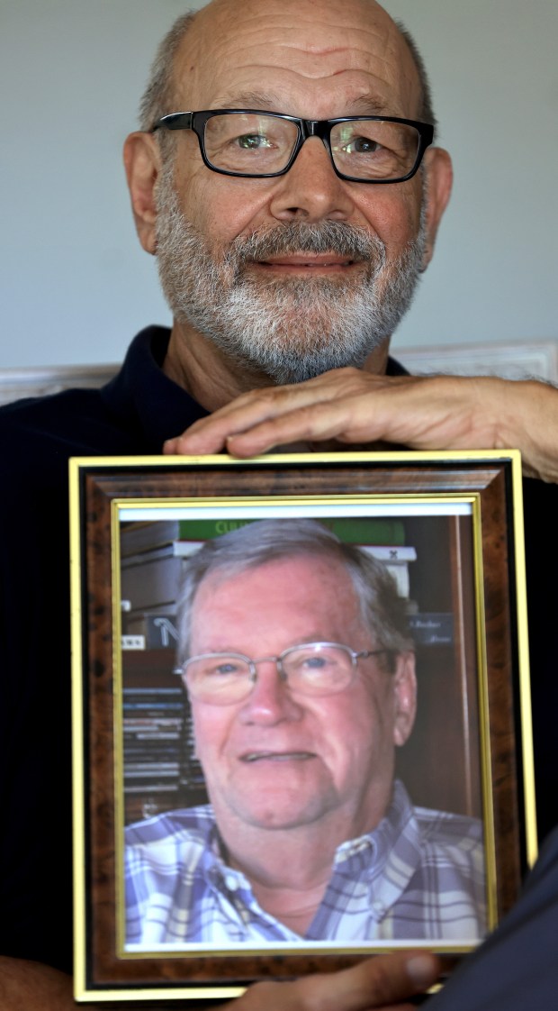 Gene Girimonte, Thursday, April 30,2026, in Santa Rosa, with a photograph of his late husband, who passed away from complications of Alzheimers. (Kent Porter / The Press Democrat)