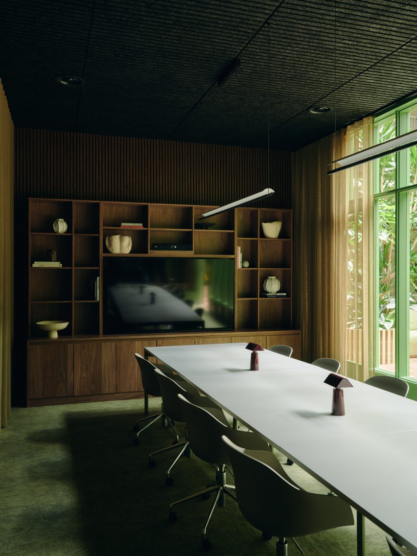 Long desk in room with green floor