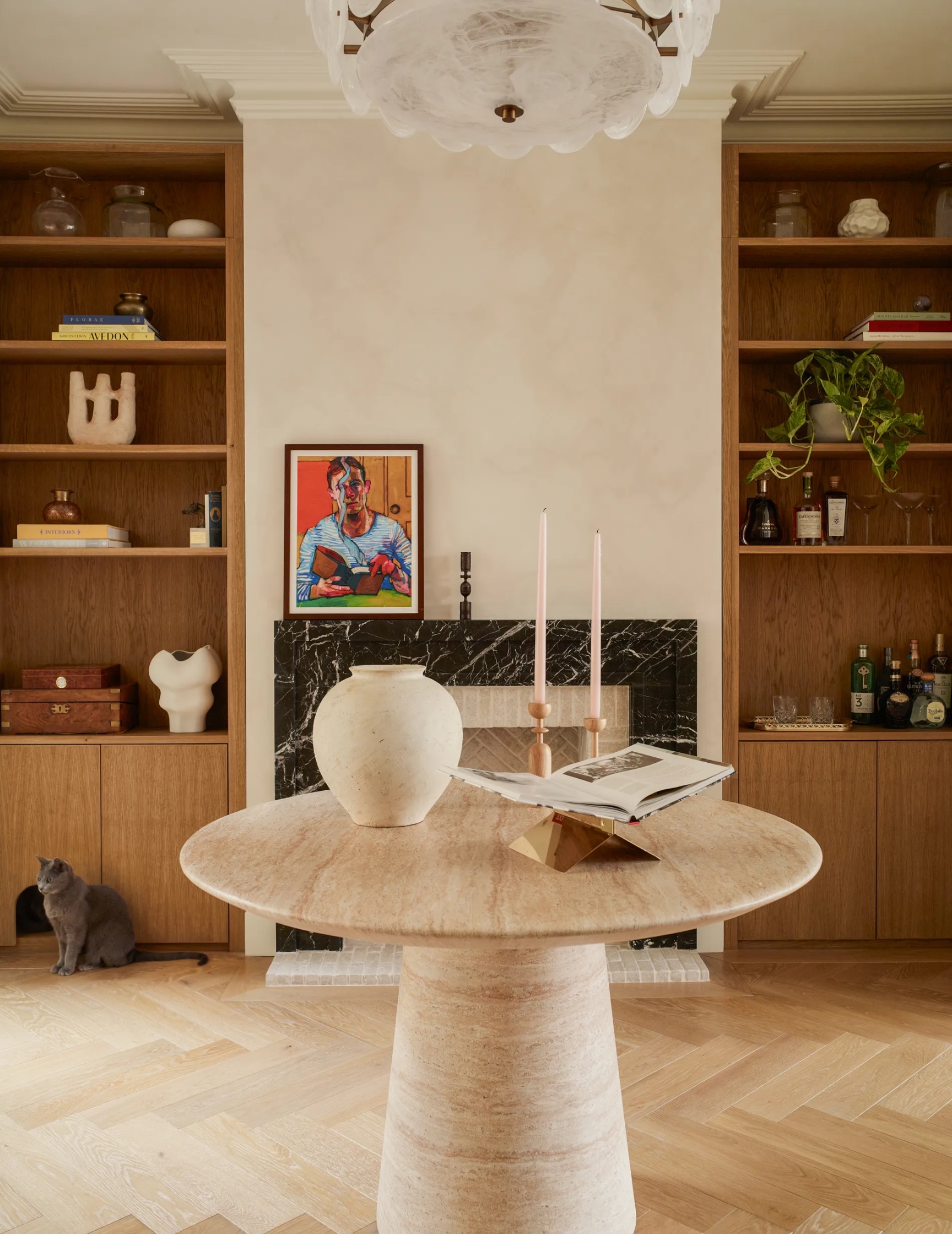a marble table in the middle of a dining space with limewash walls