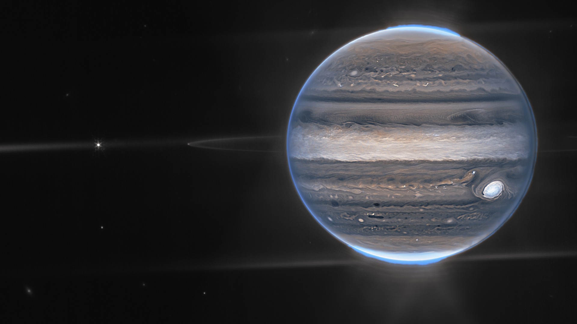 A glowing marble-like planet with faint rings around it and small white dots to the left.