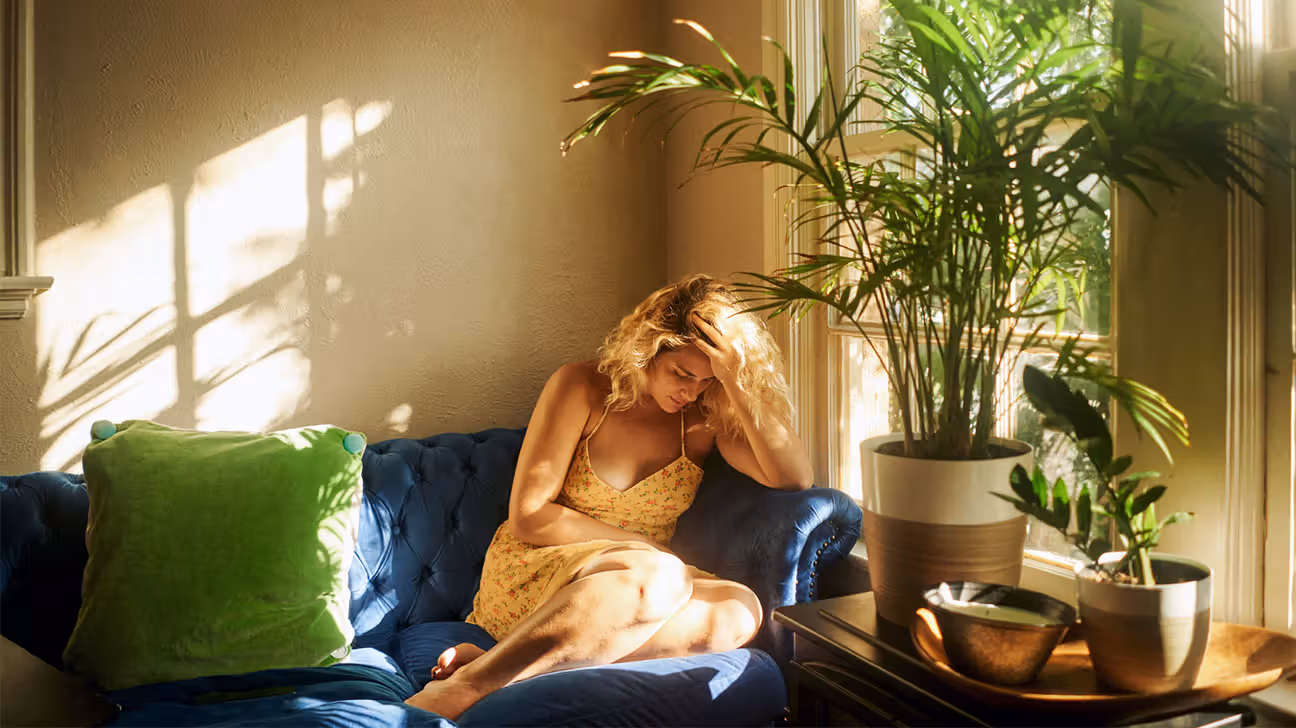 Female on couch with migraine headache