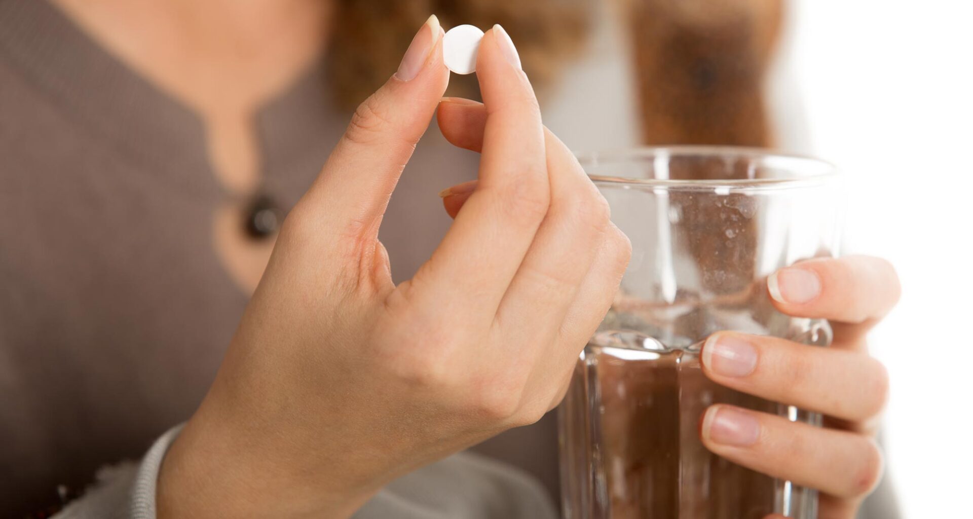 Woman Hand Holding White Pill Water Glass