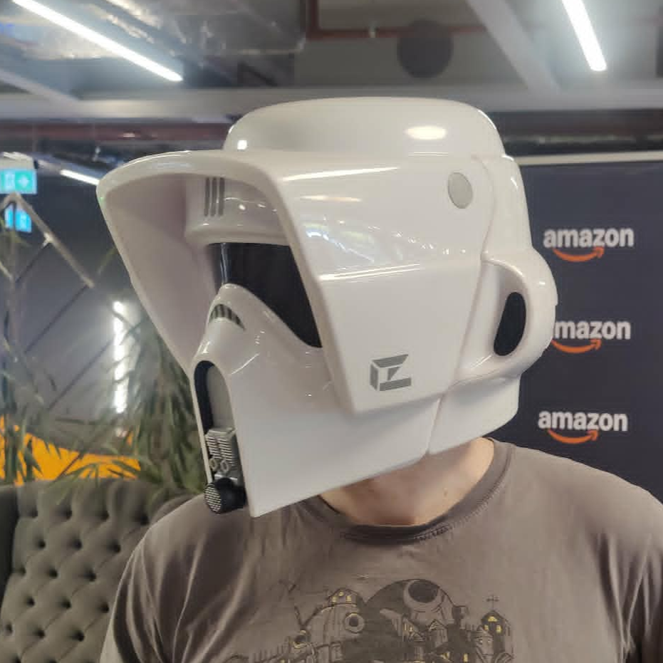 A man in a T-shift is pictured wearing a stormtrooper helmet.
