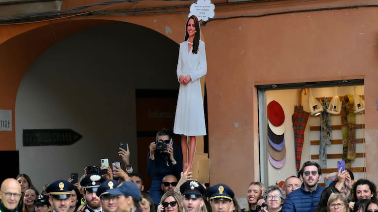 A placard of Britain's Kate, Princess of Wales, is seen through the crowd waiting outside the town hall, where the Princess of Wales is visiting as part of a two-day trip, in Reggio Emilia, Italy, Wednesday, May 13, 2026.