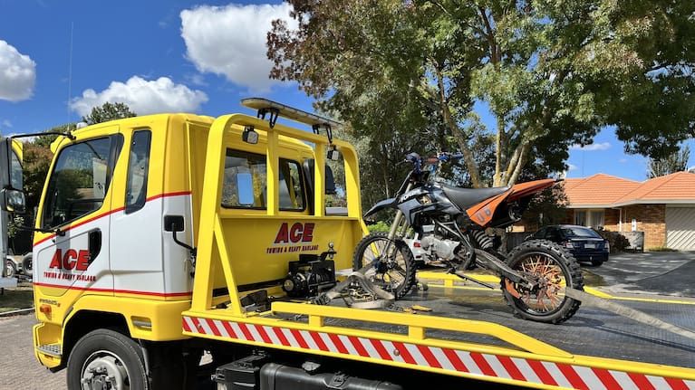 A seized dirt bike is taken away by police.