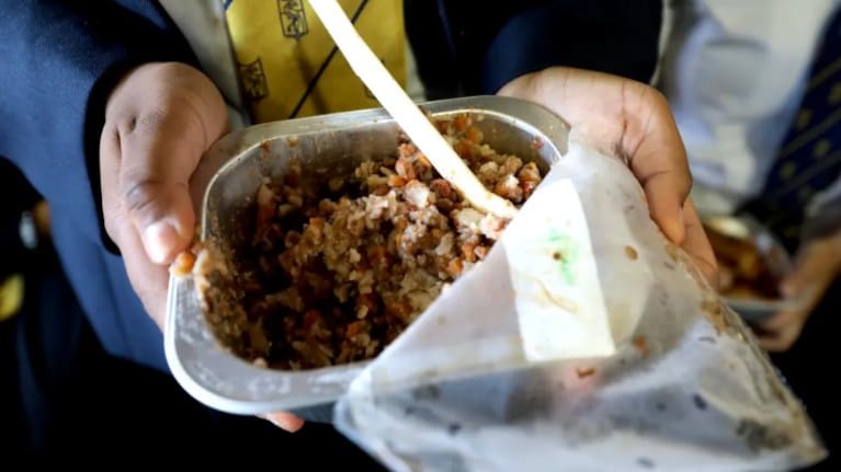 A student from Otahuhu College holds an example of a school lunch in 2025.