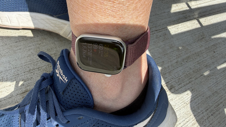 An Apple Watch tracking a workout while strapped to a woman's ankle.