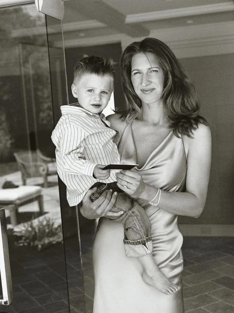 Steffi holding one of their children as a toddler