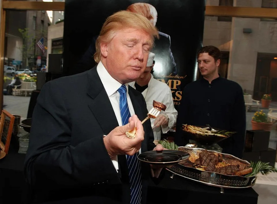 Donald Trump dines on steak stood up eating with a fork