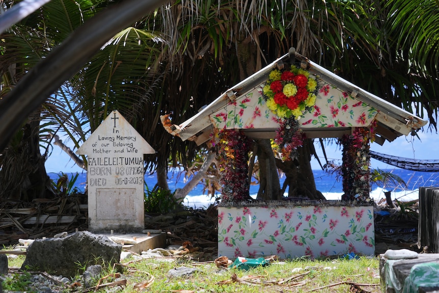 A photo of two gravestones with a backdrop of the sea.