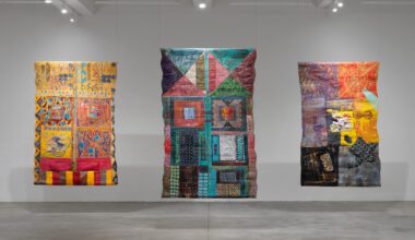 an installation image of three vibrantly painted and stitched abstract compositions by Pacita Abad