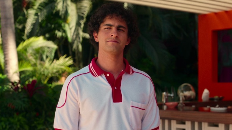 Young Maximo (Enrique Arrizon) standing in the pool area and narrowing his eyes pensively on Acapulco S1E2