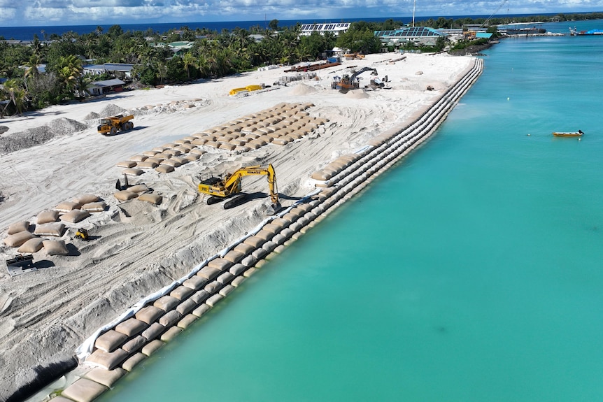 Rows of sandbags are stacked over time providing a protective barrier to newly reclaimed land areas.