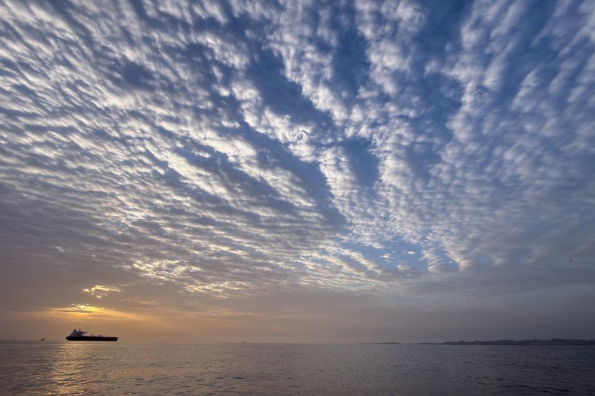 The sun rises behind a tanker anchored in the Strait of Hormuz off the coast of Qeshm Island, Iran.