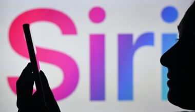 An image of a woman holding a cell phone in front of the Siri logo displayed on a computer screen.