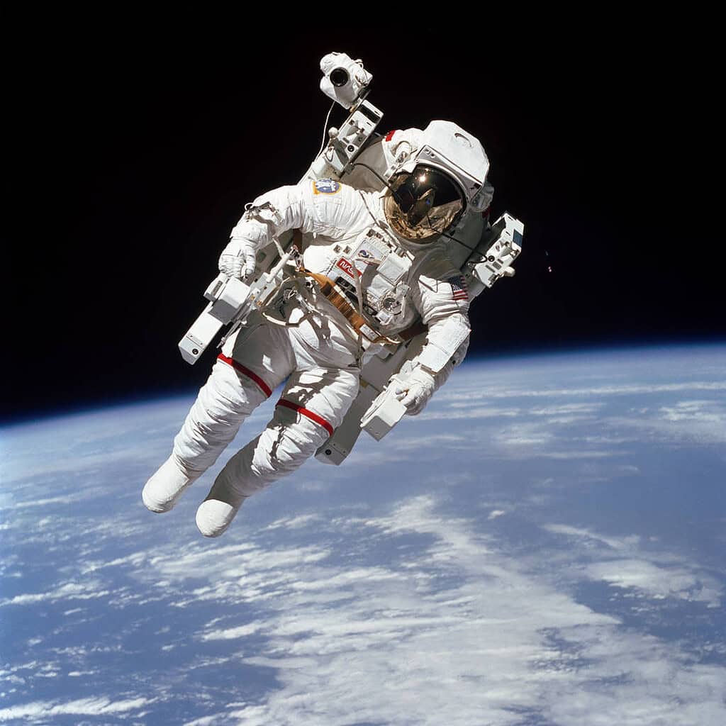 Astronaut performing a spacewalk outside the International Space Station in orbit.