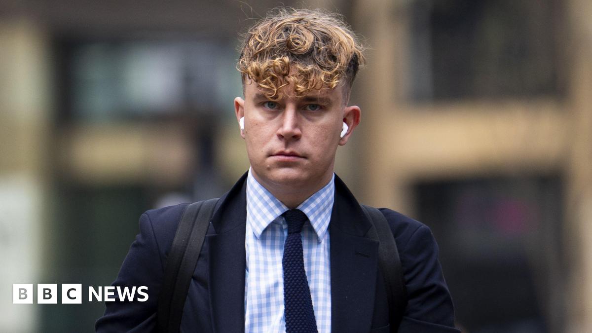 Lewis Rollins wearing a black suit walking into court.