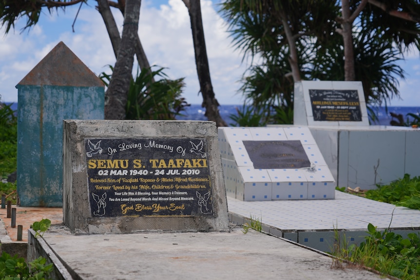 A photo of gravestones with a backdrop of the sea.