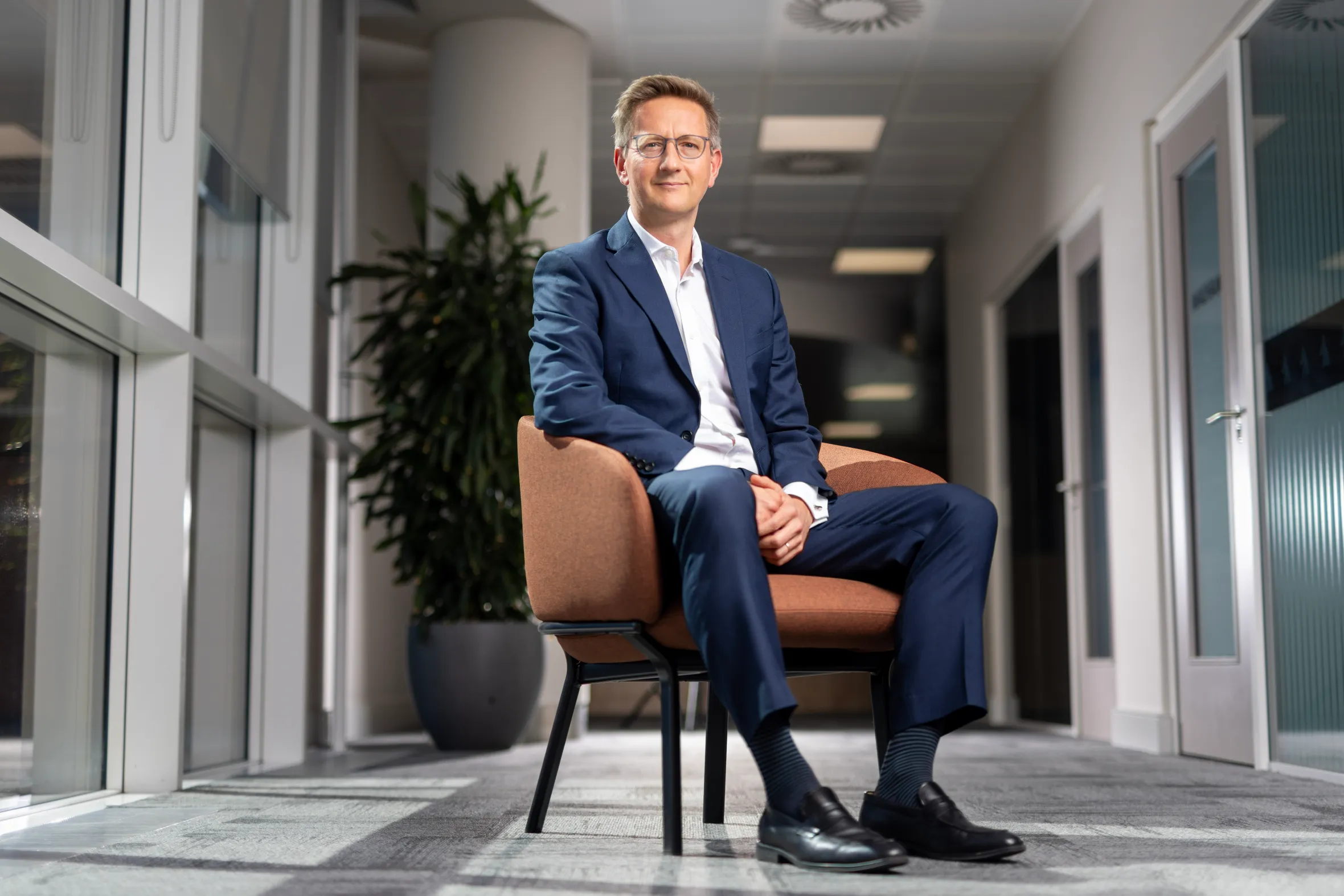 Oliver Holbourn, CEO of the National Wealth Fund, sitting in an office chair.