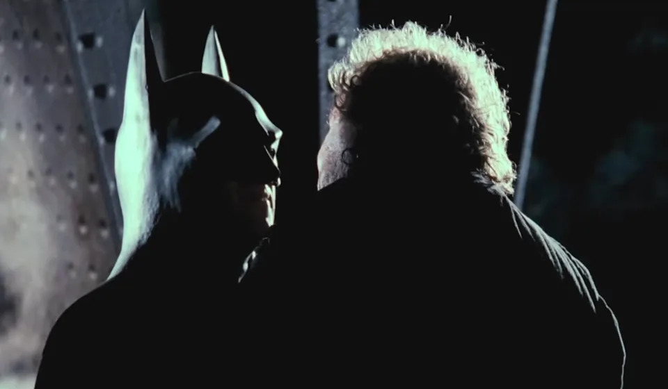 Batman holding up another man