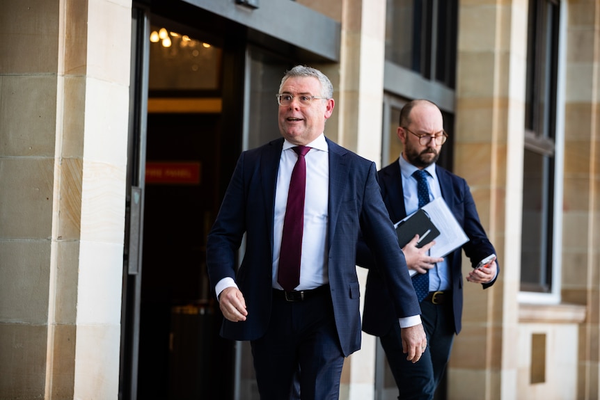 Murray Watt walking out of a building.