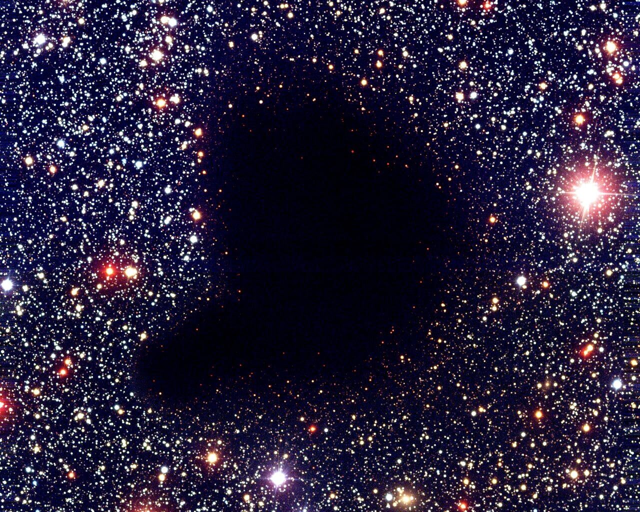 Barnard 68, a dark molecular cloud where dust grains shield the densest interior from UV radiation and catalyze the formation of complex molecules. (CC BY 4.0, ESO)