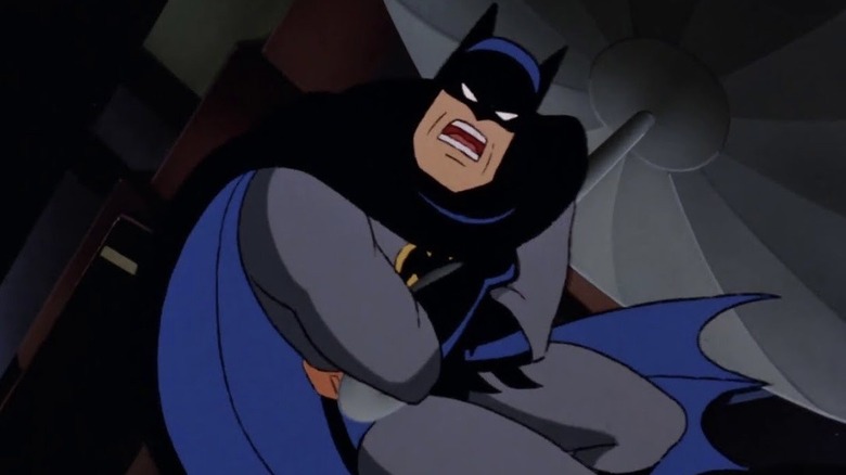 Batman clings onto the end of a zeppelin, delivering his iconic 