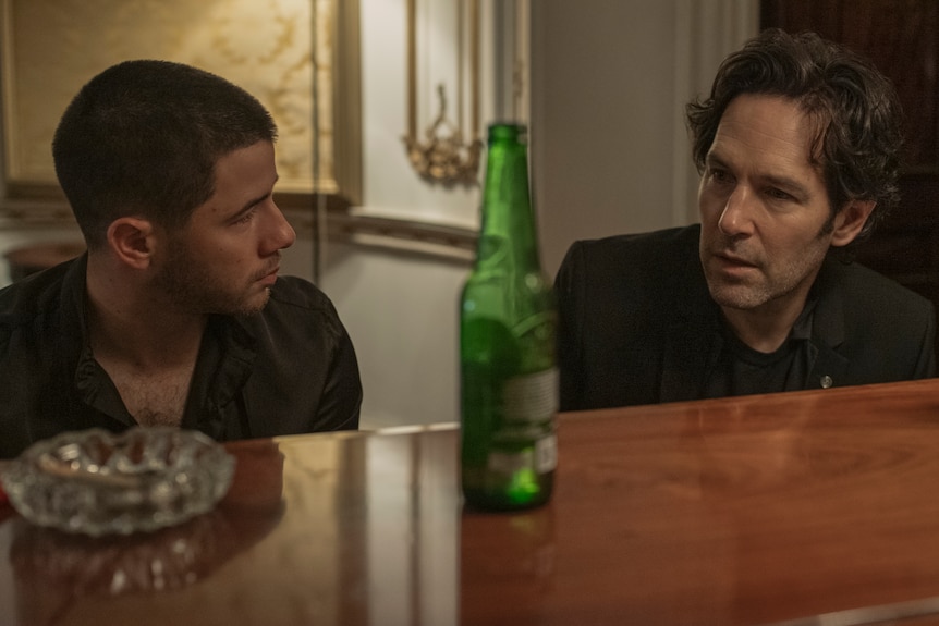 Two men sit at a piano