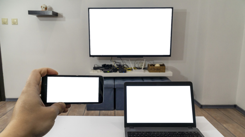 a phone, laptop, and tv displaying a blank white screen on each device