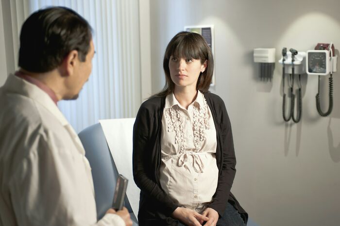 Pregnant woman consulting with doctor in medical office