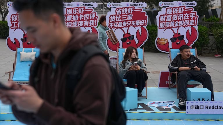 Shoppers rest at a RedClaw AI promotion booth set up outside a shopping mall in Beijing