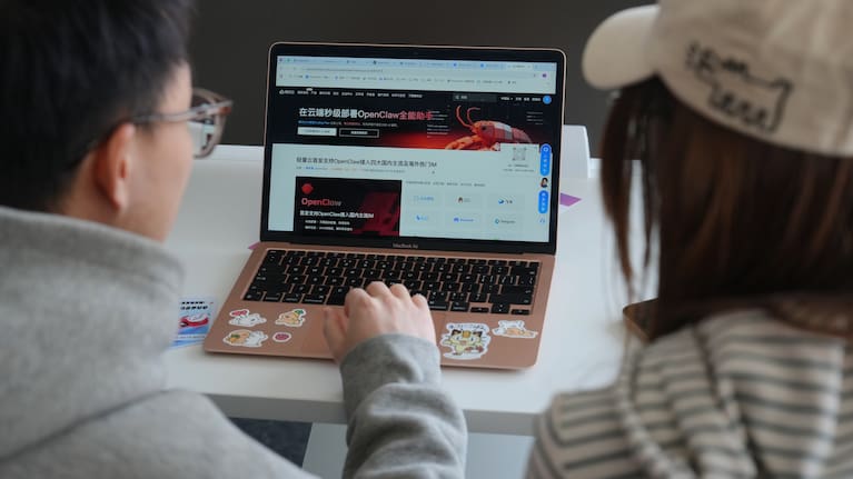 A staff member, left, helps a woman to install the RedClaw AI software on her laptop at an office in Beijing