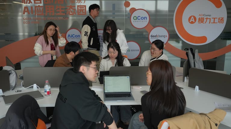 Staff members help their customers install the RedClaw AI software on their laptops in Beijing
