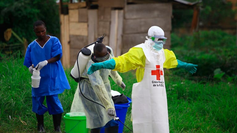 A health worker sprays disinfectant on his colleague after working at an Ebola treatment center in Beni, eastern Congo, Sept 9, 2018.