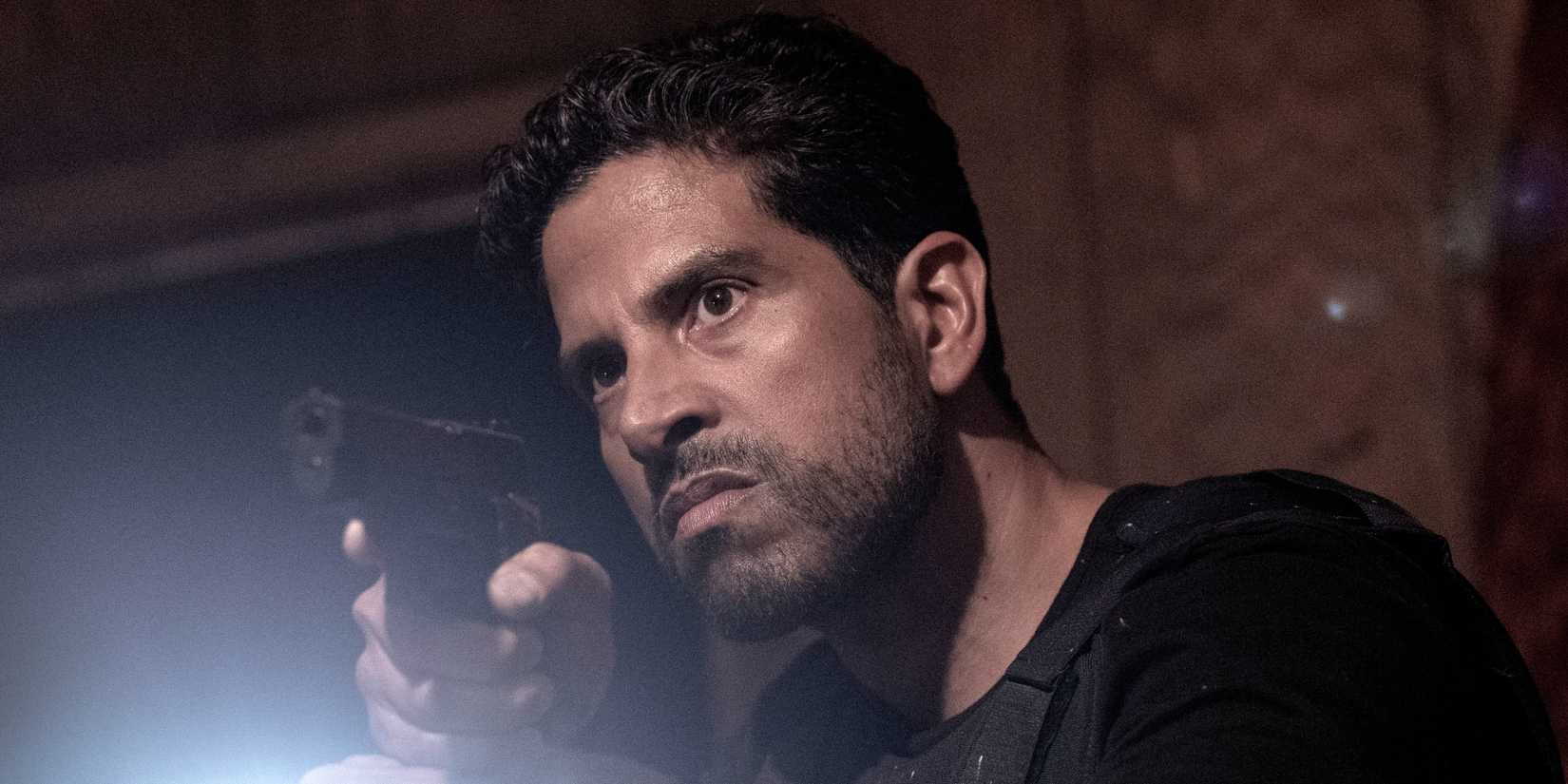 Adam Rodriguez as Luke Alvez holding up a gun and a flashlight in Criminal Minds: Evolution