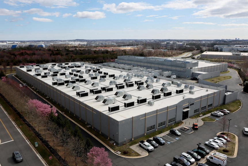 An aerial view of a large data centre warehouse in a suburban area.