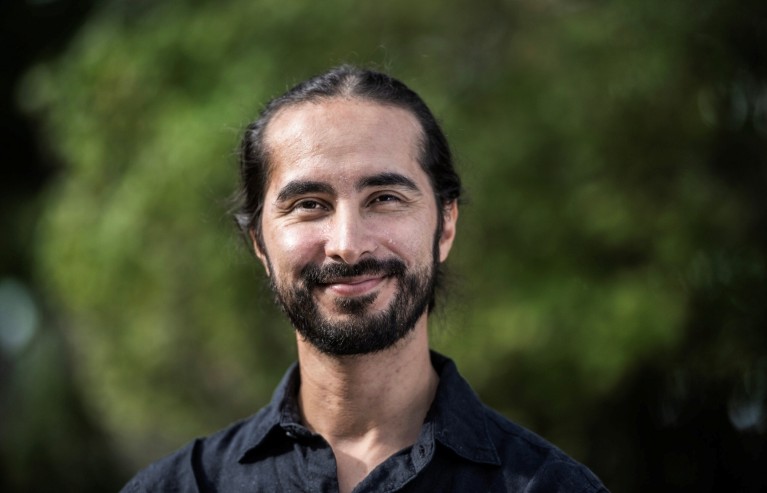Smiling portrait of Juan Rocha outside.