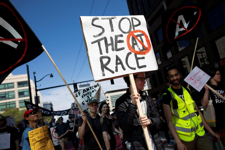 A protester with a sign reading 'Stop the AI Race' walking among other demonstrators down a city street.