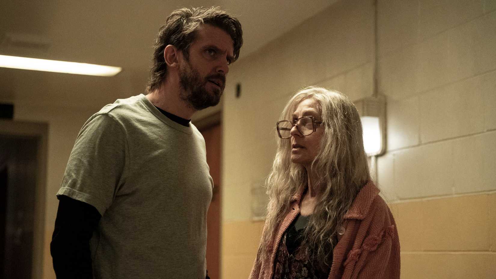 Pepper (Dan Stevens) stares down a hallway looking nervous while Dorry (Judith Light) looks up at him.