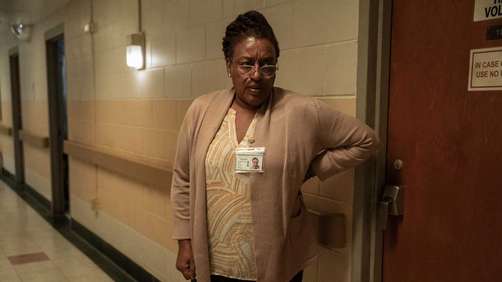 Miss Chris (CCH Pounder), a nurse wearing a sweater and a name tag, stands in a hallway looking stern in The Terror: Devil in Silver